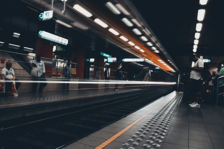 several people on a subway platform in a subway