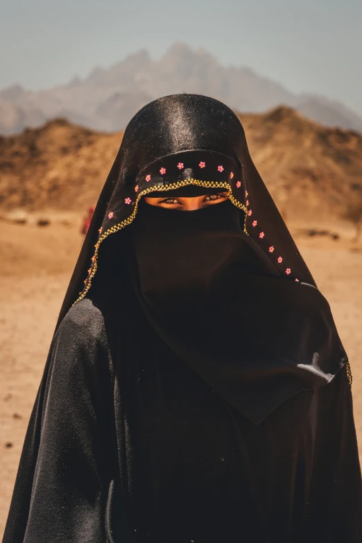 the woman in the black jacket wears a head scarf