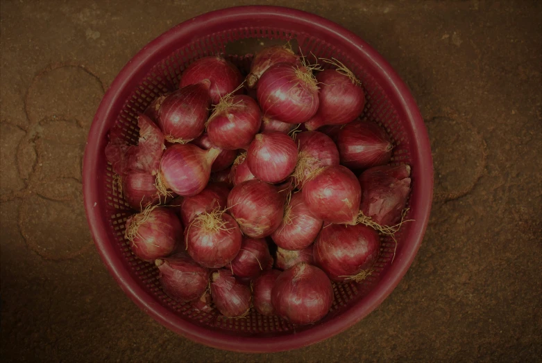 a pile of onions in a red bowl