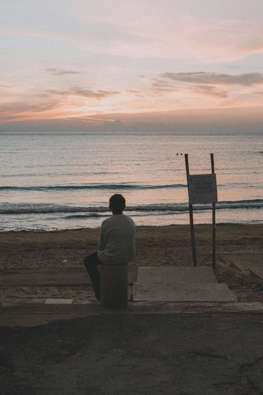 a man sitting on a mat looking at the ocean