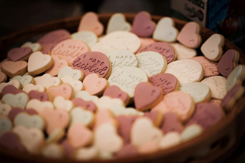 several valentines day cookies are in a wooden dish