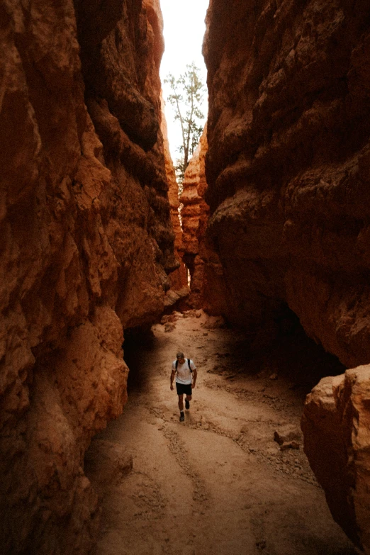 a person with backpack walks along the rocks