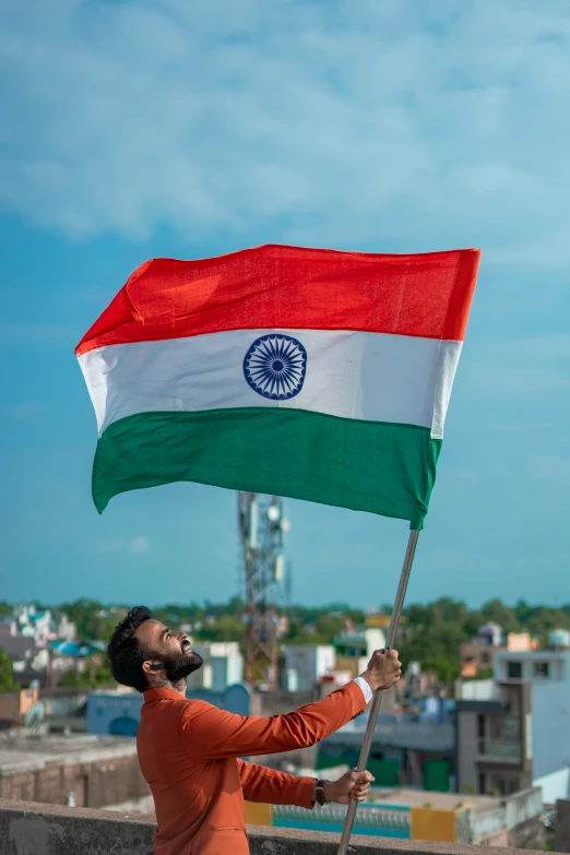 a man in an orange shirt holding a flag