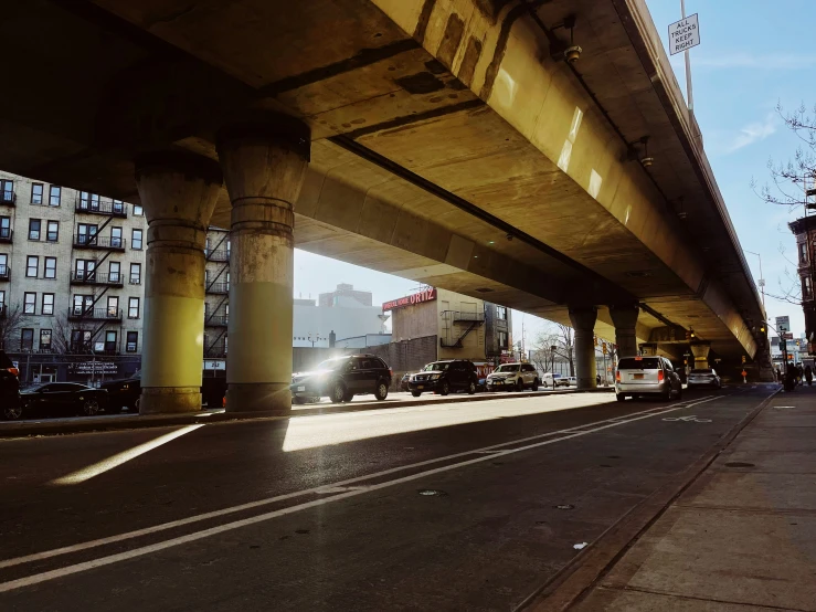 some cars going under an overpass in an intersection