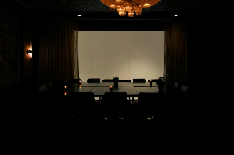 dark, room setting with lighting from the window and chandelier