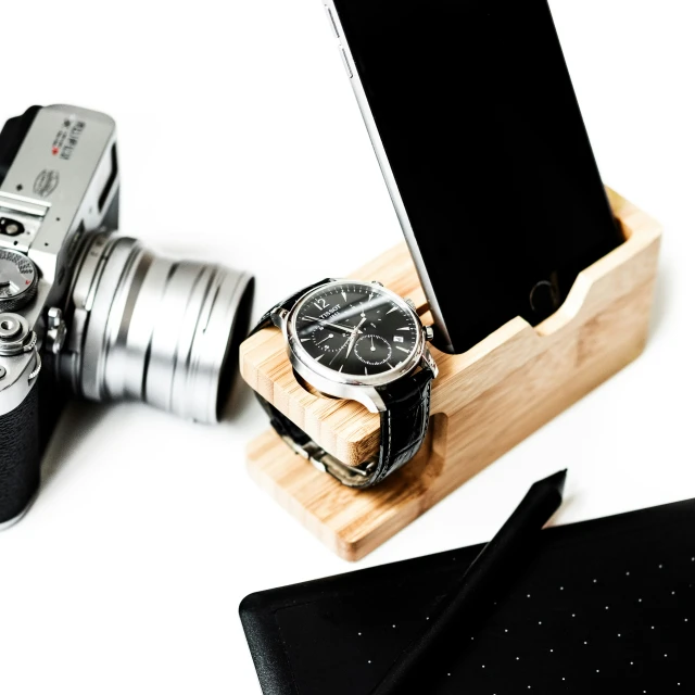 a wooden case for a camera holds a watch