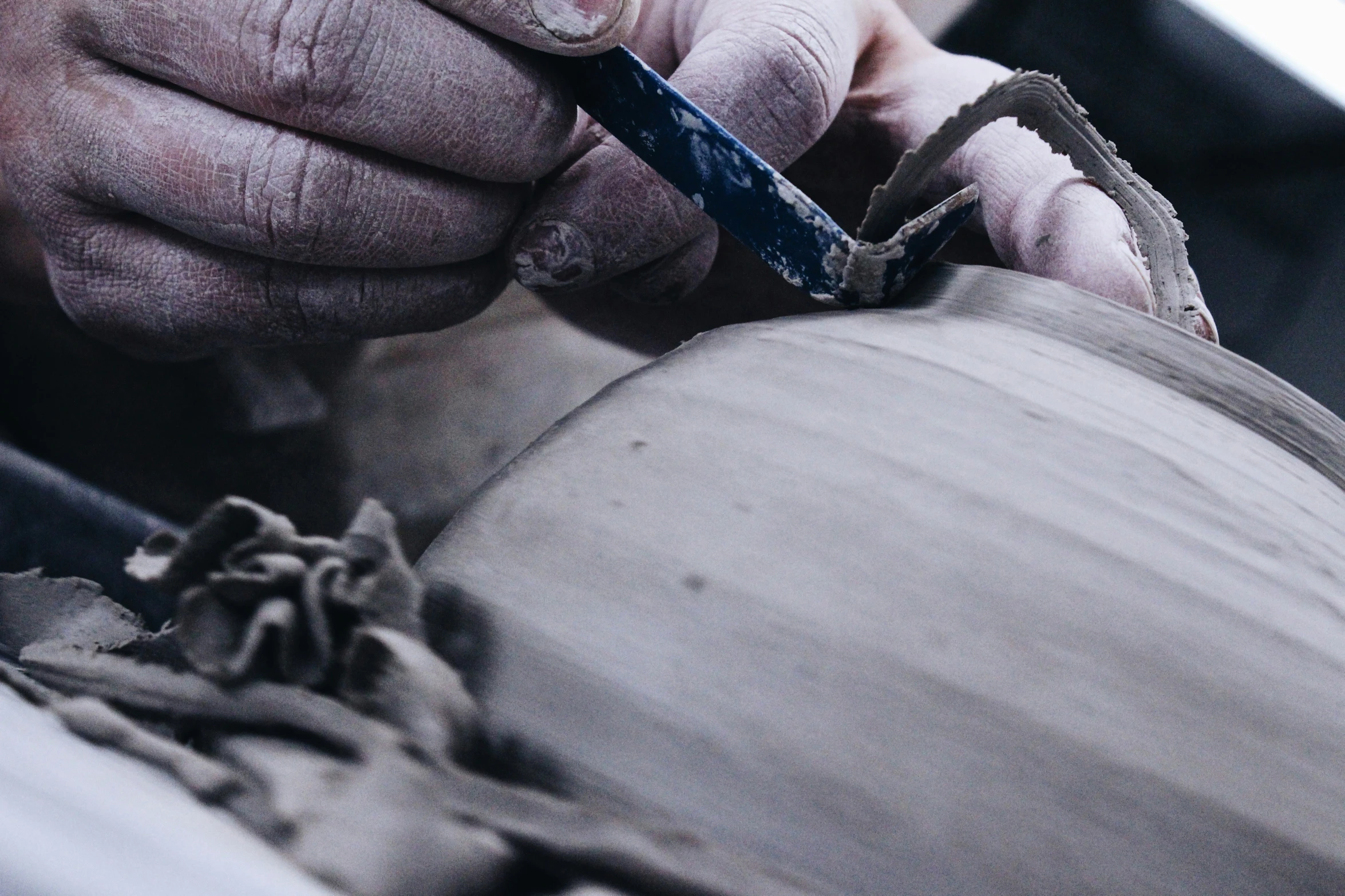 a person is carving soing off of a clay pot