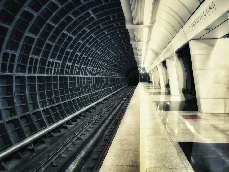 a train is moving in the tunnel with its lights on