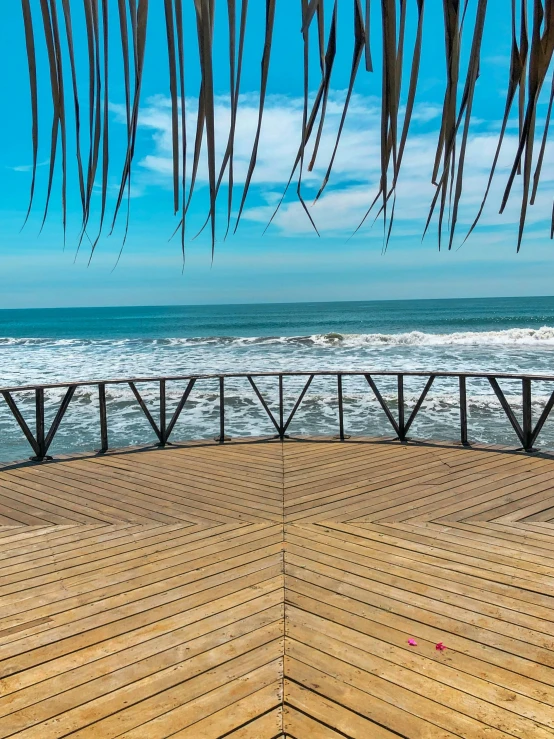 a bench sitting on the side of a boardwalk near the ocean