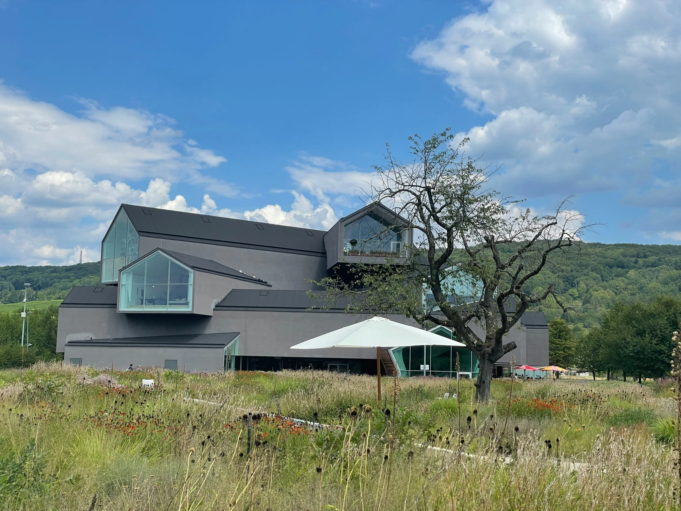 the building has a large deck and umbrella outside