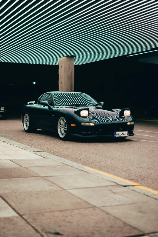 a car with a ze stripe covering is parked