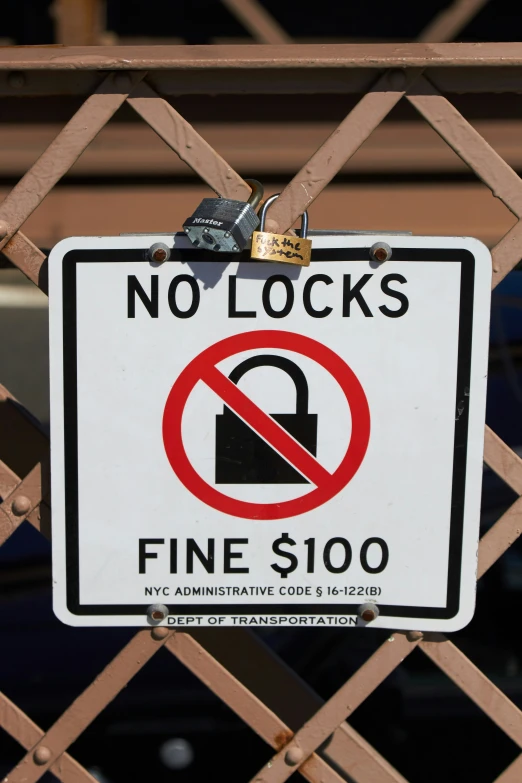 a white and red sign attached to a wooden gate