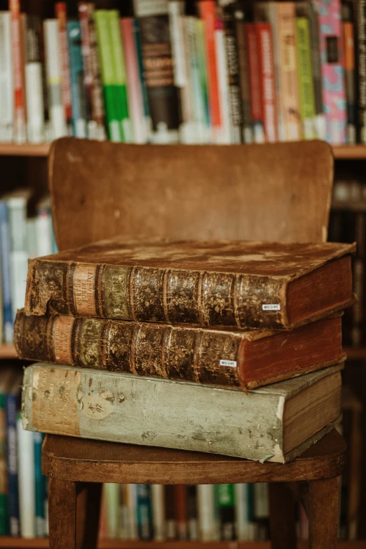 an old leather suitcase is stacked on a wood desk