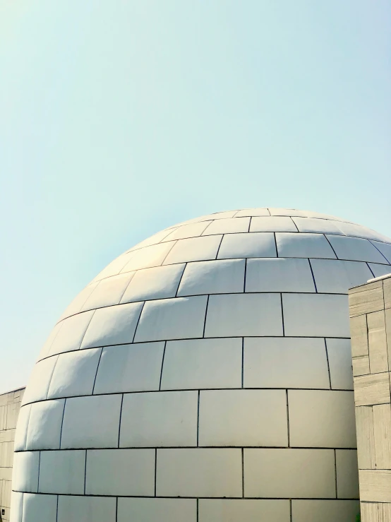 an artistic dome building in the middle of a park