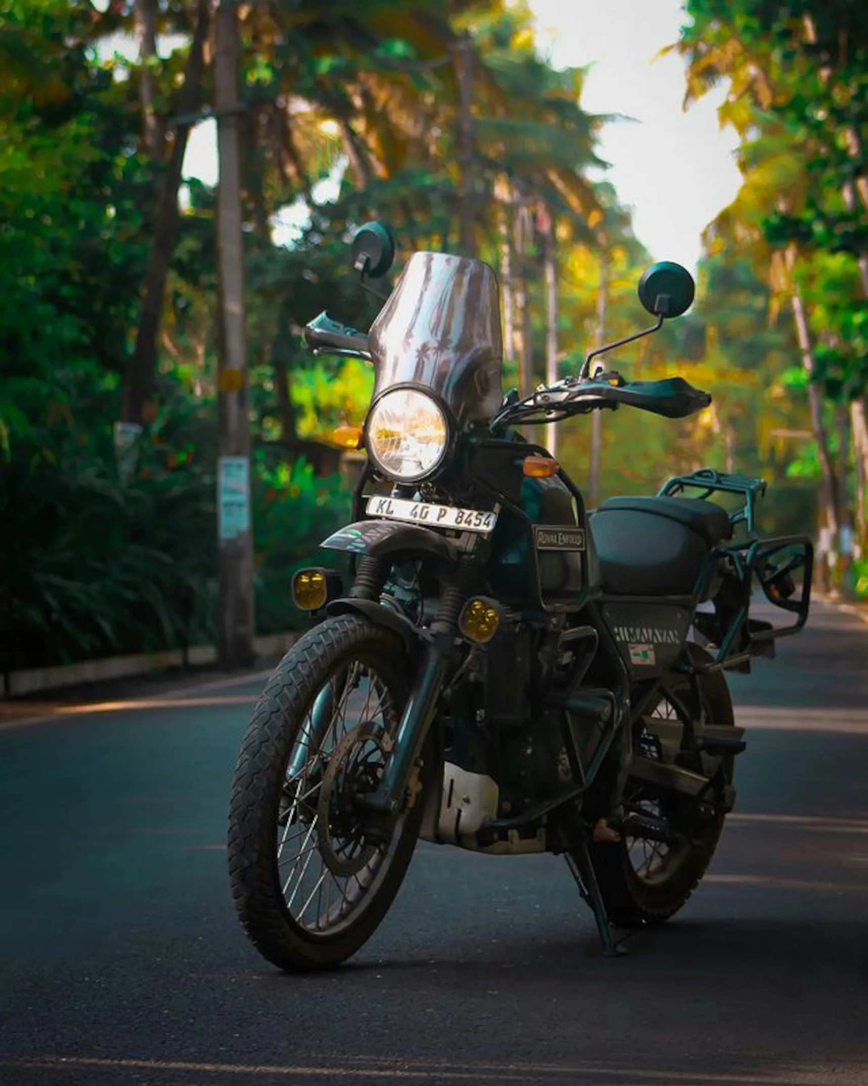 a motorcycle parked on a street with trees in the background