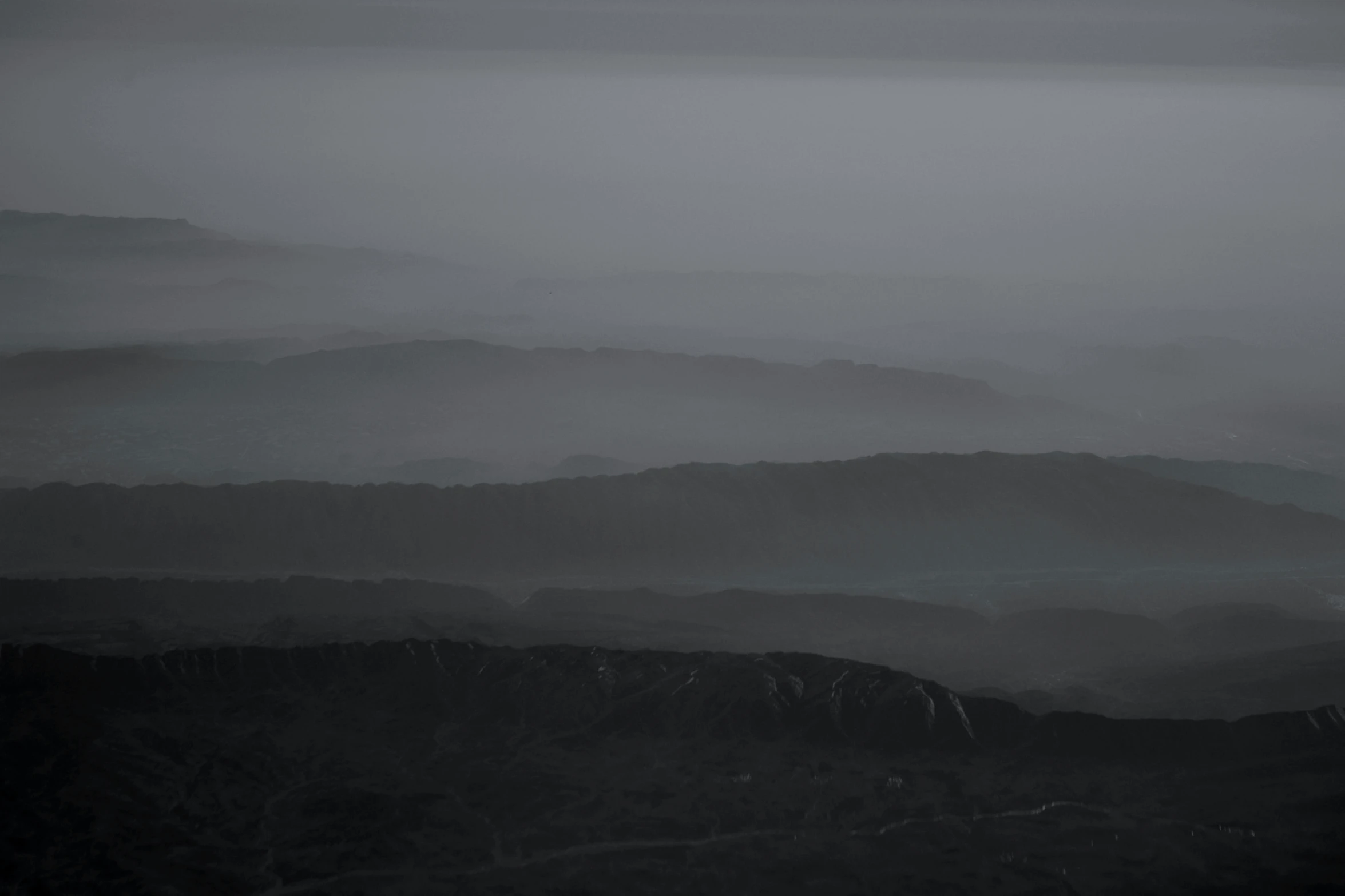 black and white po of the tops of mountains in the fog