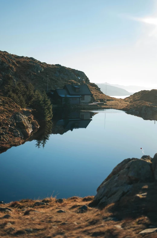 a clear body of water with a house on the side