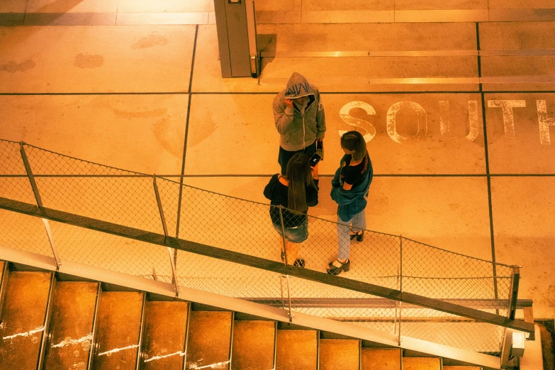 a couple stands on a stairwell near a street sign