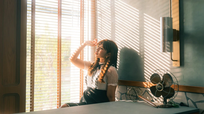 a young woman sitting on a table looking out the window