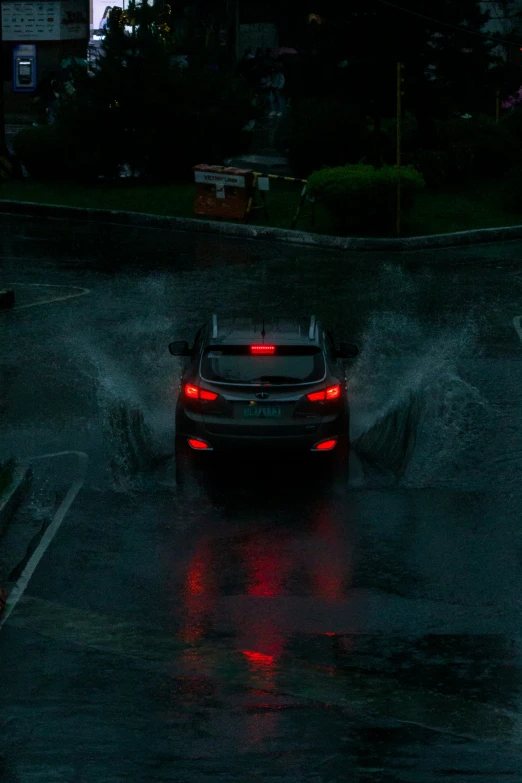a car with its ke lights turned on in the rain