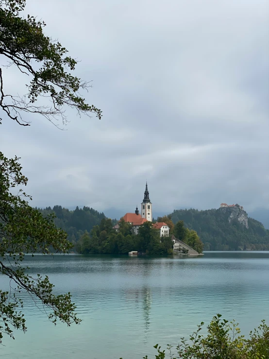 a small island in the middle of a lake with an old church on it