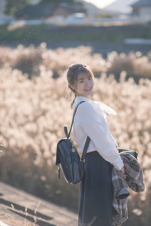 a  standing outside in front of some tall grass