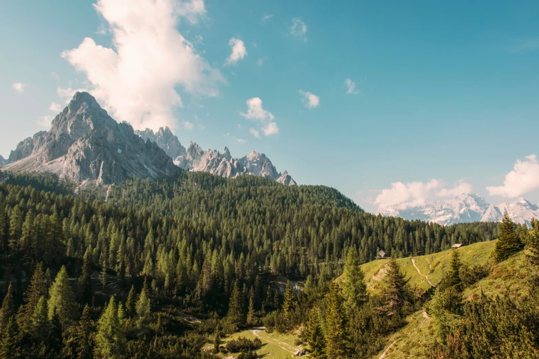 trees and mountains are in the distance with clouds