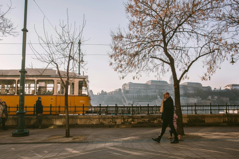 two people walk near a river side bus station