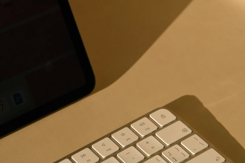 an apple keyboard with a picture on the monitor in the background