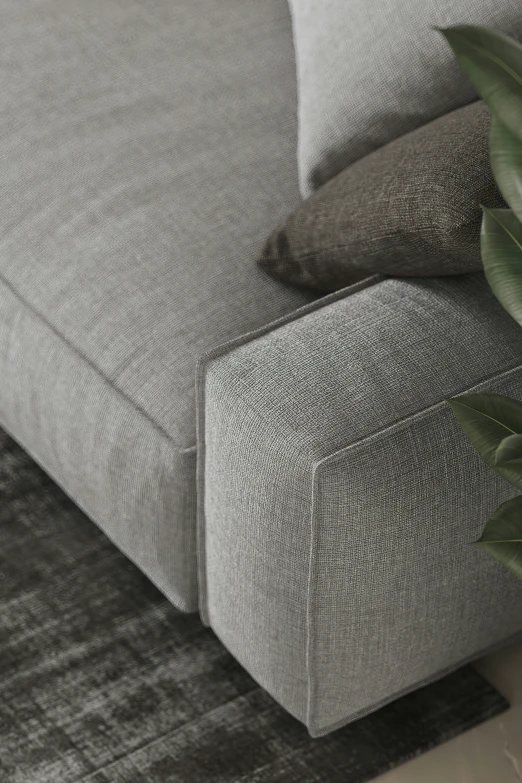 the corner of a couch with some plants on top of it