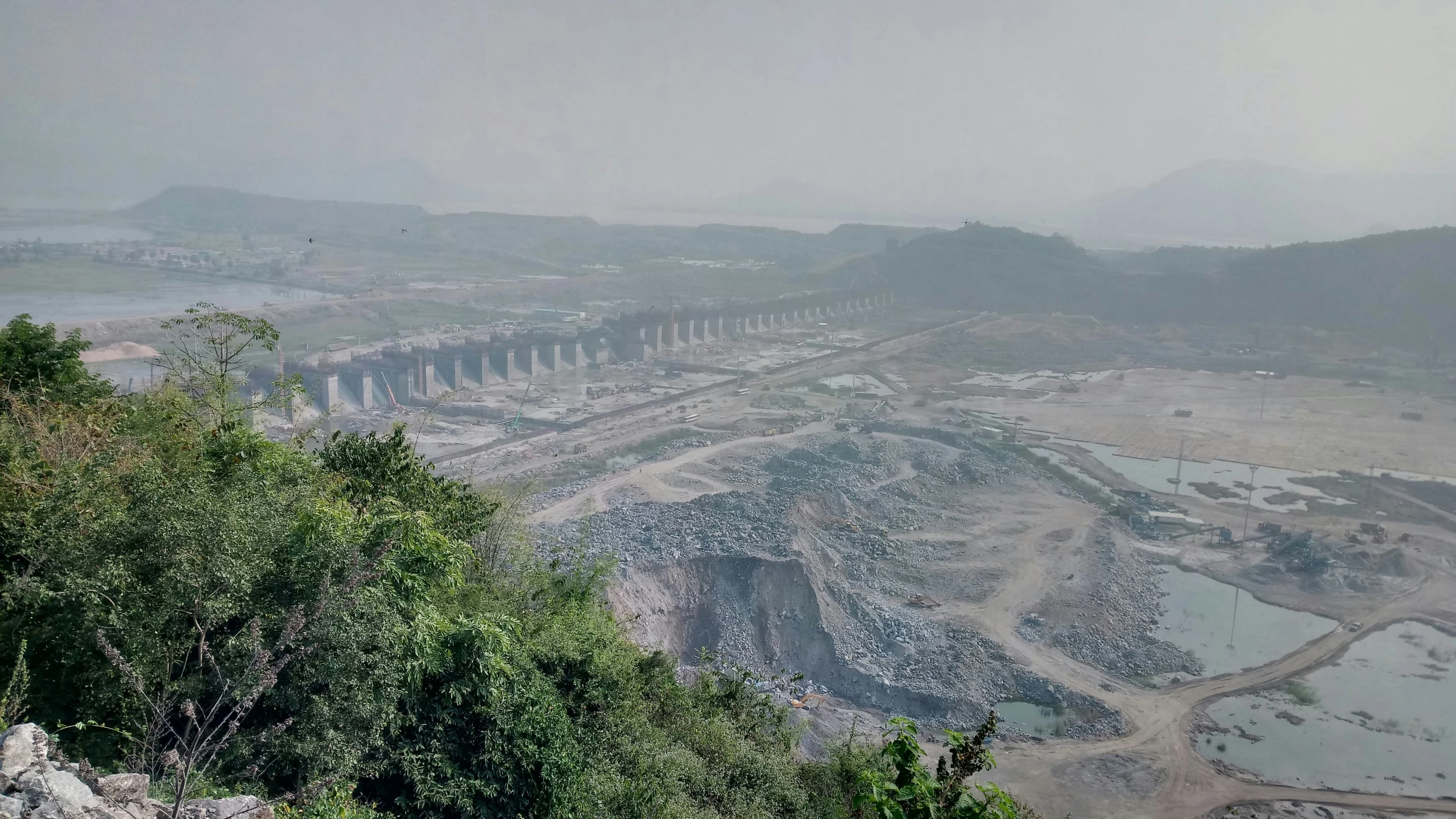 a hilly area with rocks and trees on the left