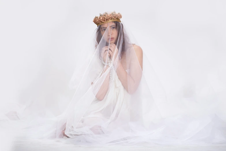 woman wearing veil and veillet and dress posing with white veil