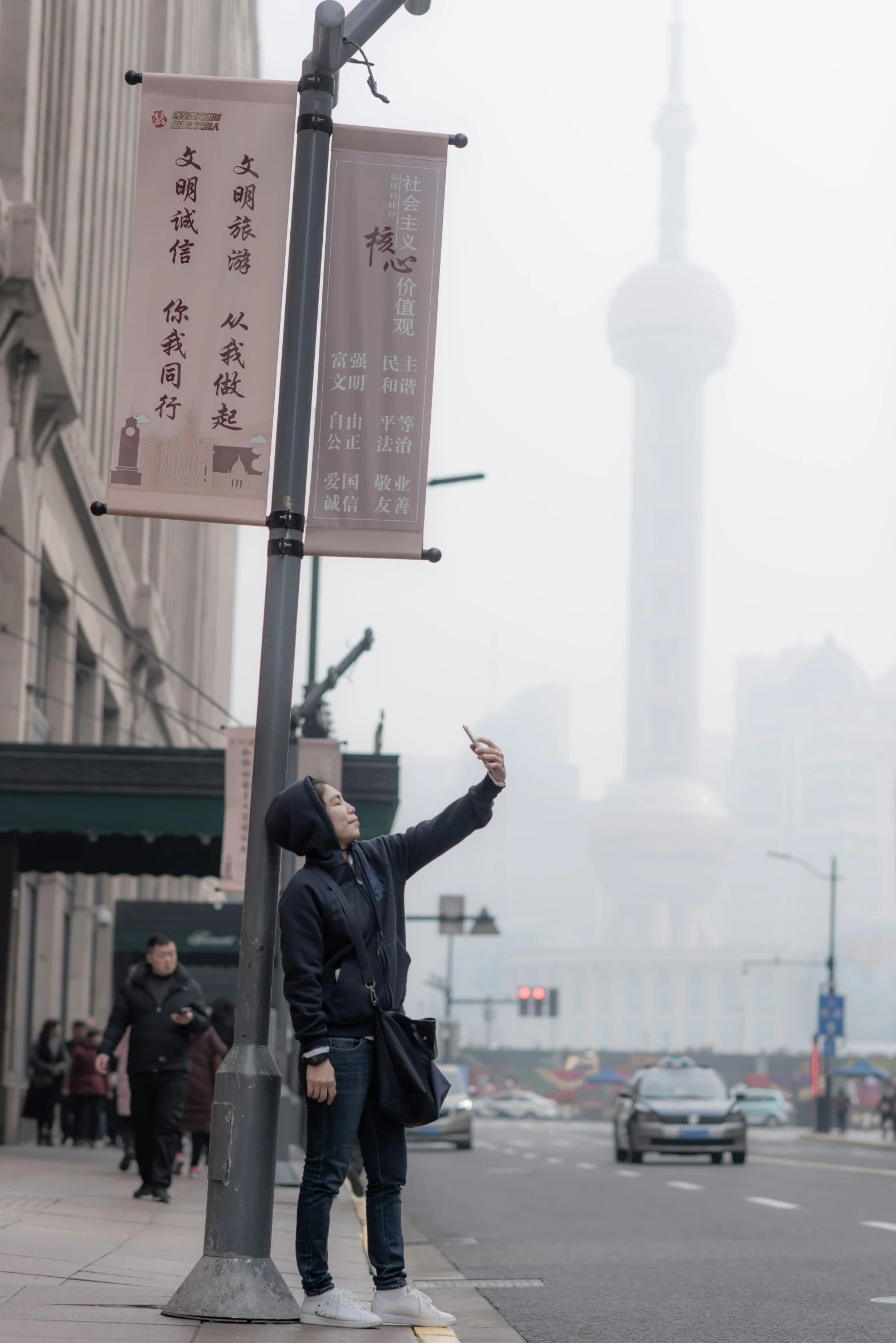 a person standing under a traffic light on a foggy day