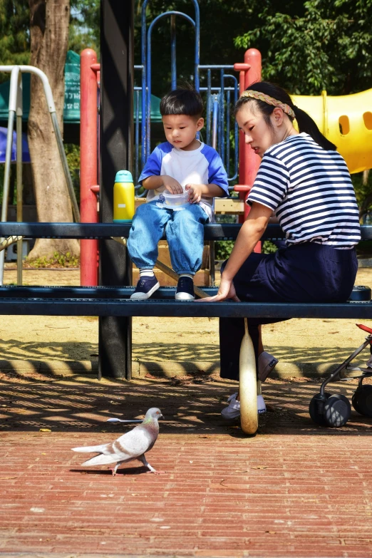 two s and a little boy play on a wooden bench