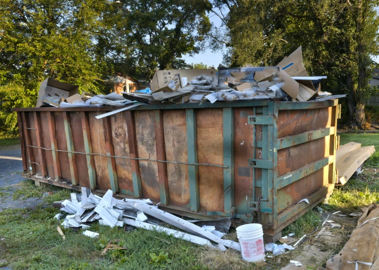 a garbage bin filled with scrap is outside