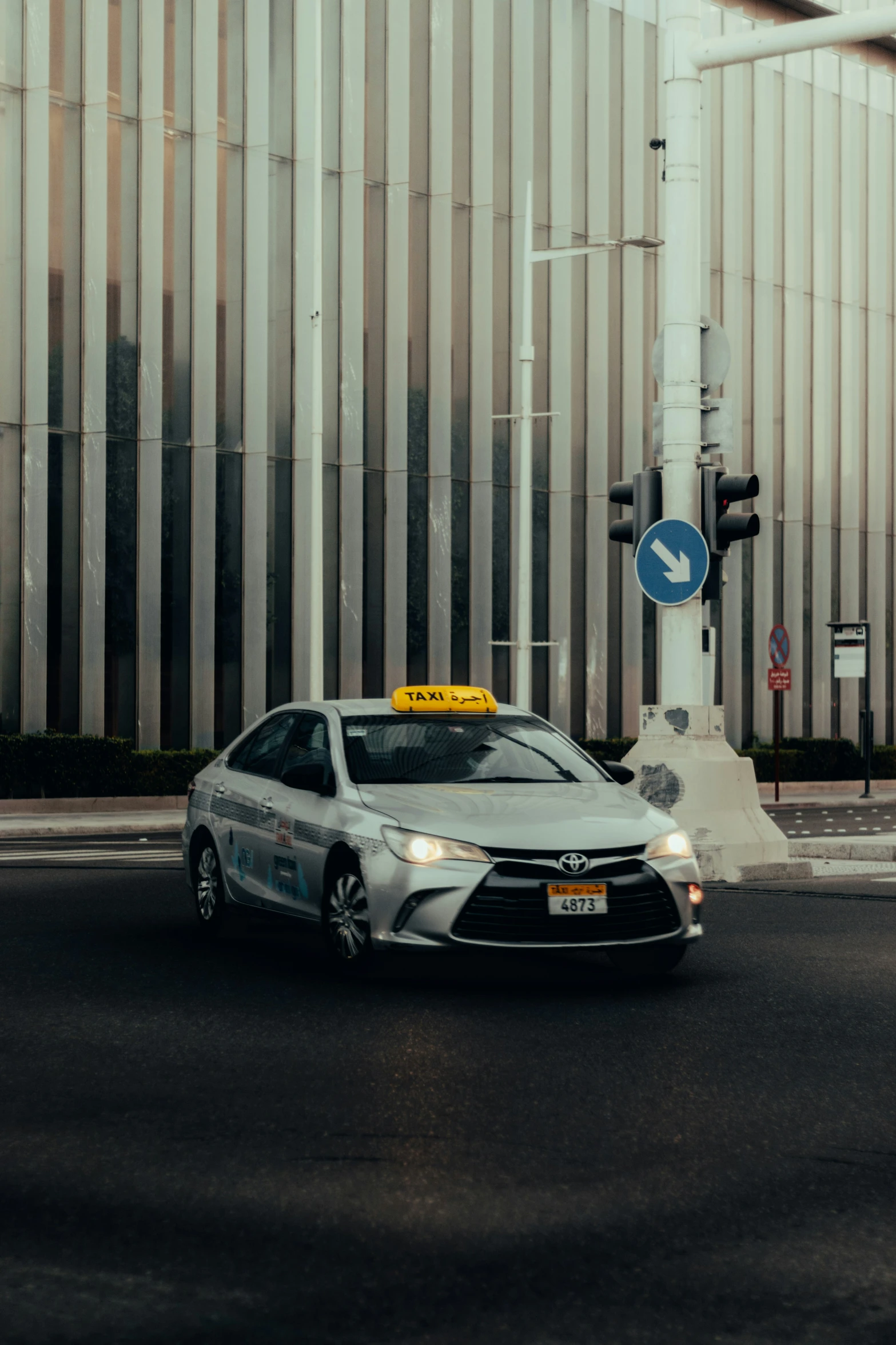 a silver toyota mira that has a yellow traffic signal