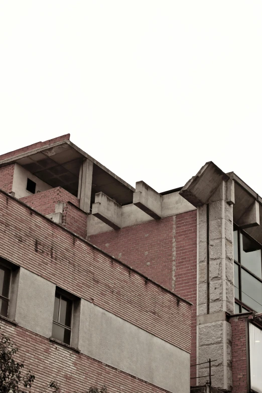 looking at an abandoned brick building against a grey sky