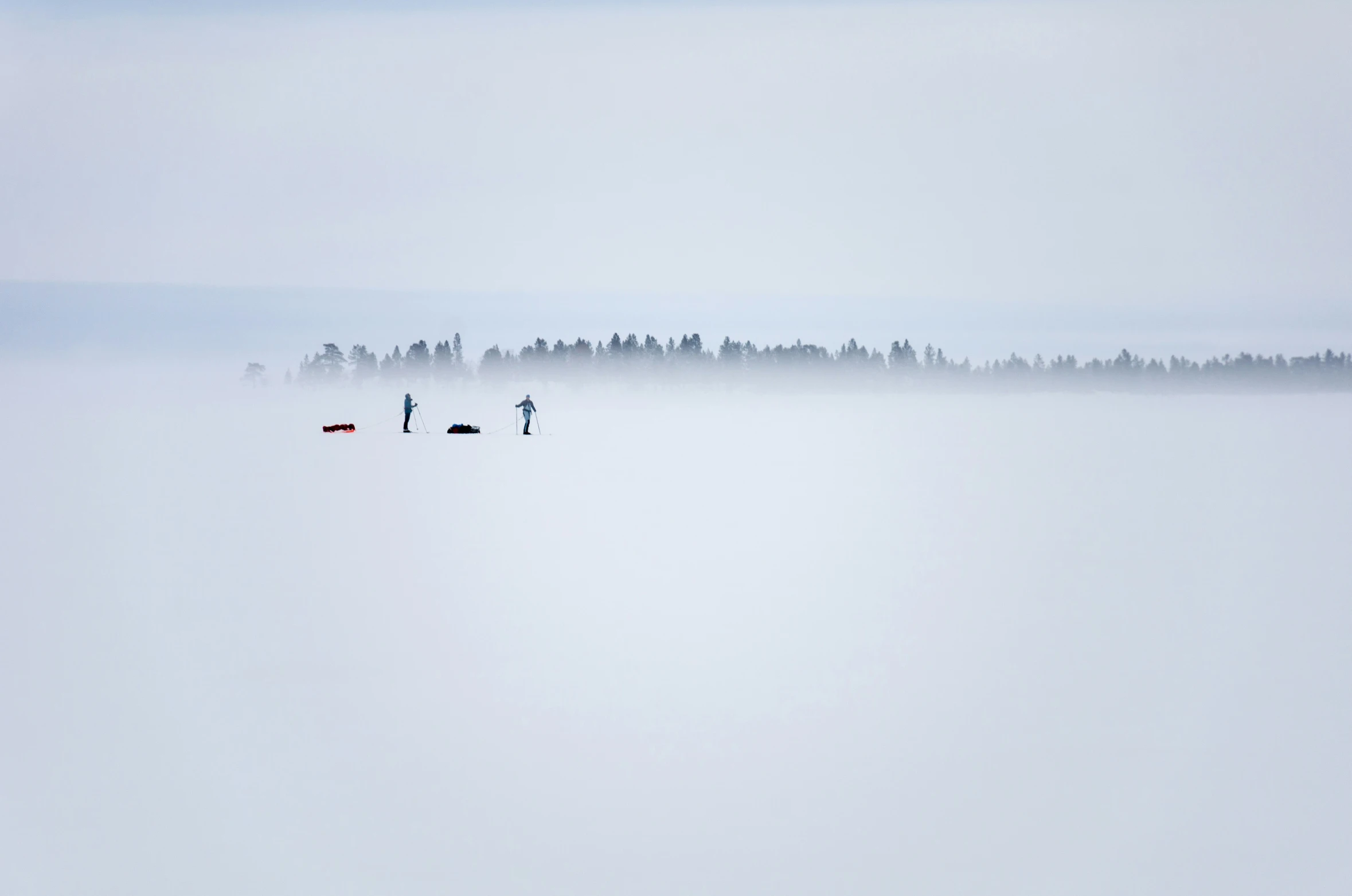 a group of people walking across a snow covered field