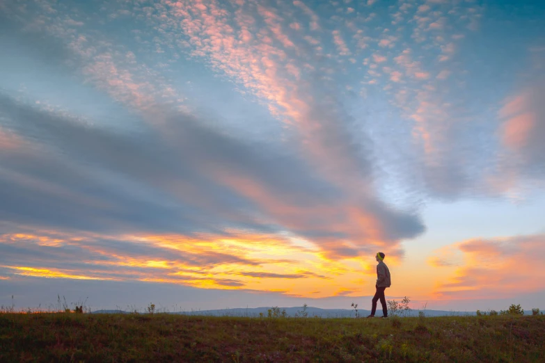 a person on top of a hill at sunset