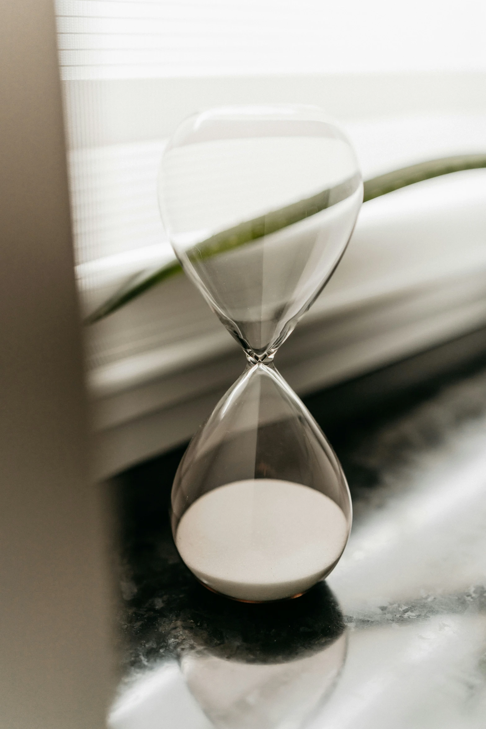 an hourglass on top of a counter next to a window