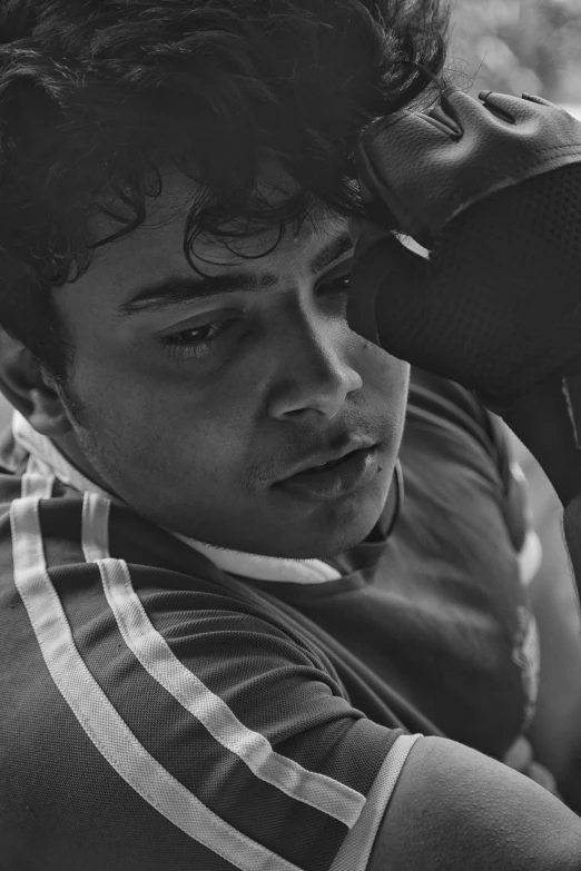 a black and white image of a child holding his hands in his ear