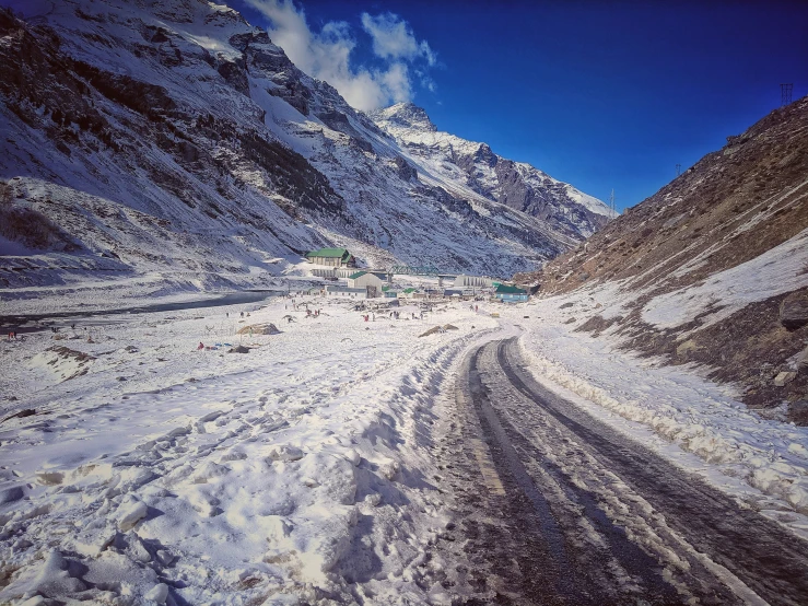 a snowy road in the mountains next to a building