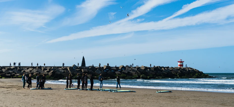 some people are on a sandy beach near the water