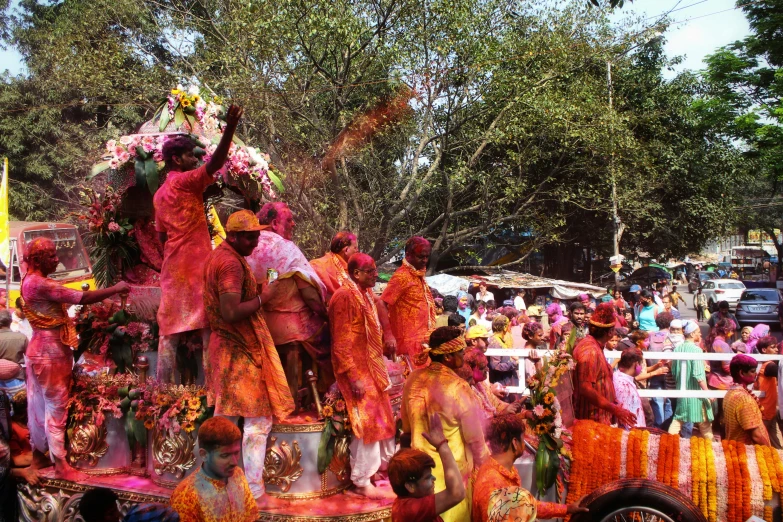 the colorfully dressed men and women on a float during a parade