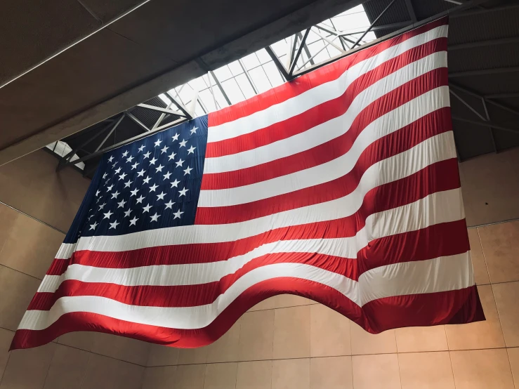 large american flag hung in front of a light fixture