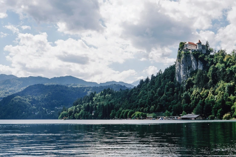 a beautiful, mountainous scene with a lone house on a small cliff