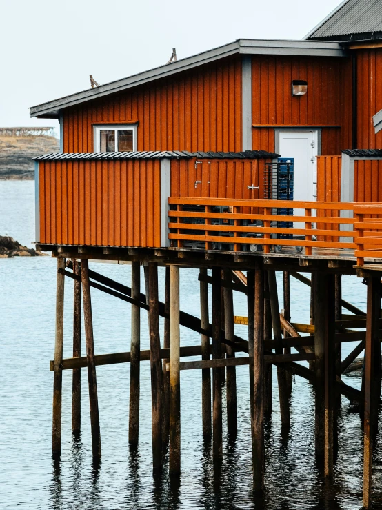 a yellow wooden pier with an orange building on it