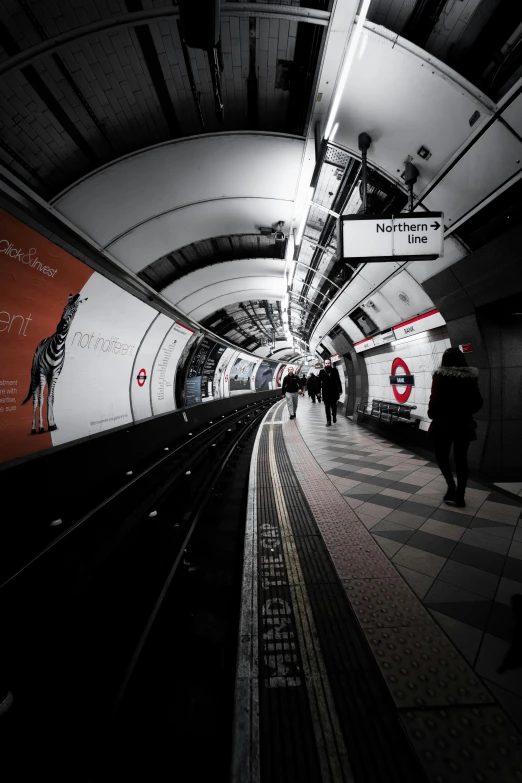 a group of people are walking down a platform