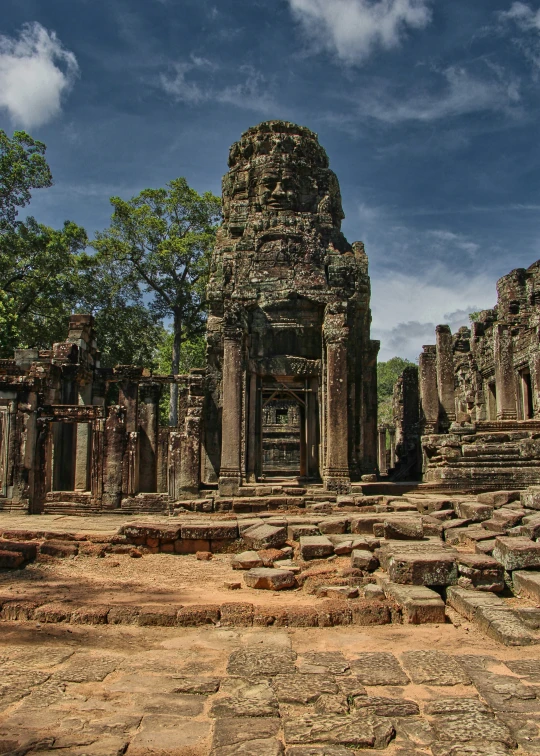 a line of trees in the background with large stone structures surrounding