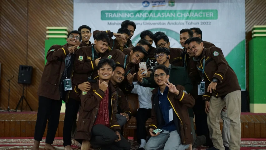 a group of guys wearing brown and green posing for a po together